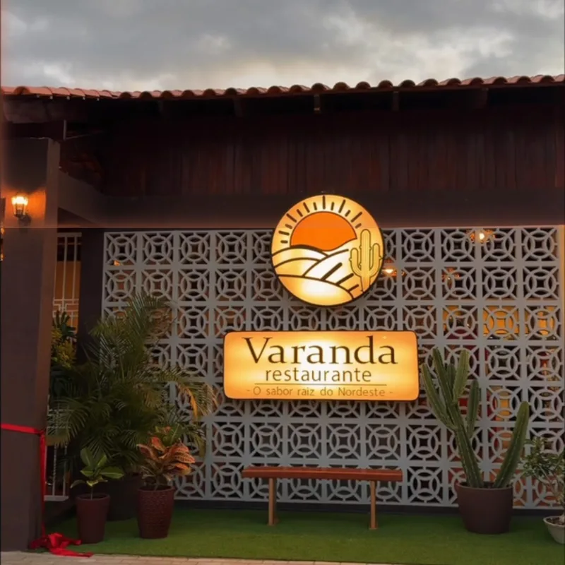 Fachada do Varanda à noite, com o letreiro aceso sobre a parede de cobogó