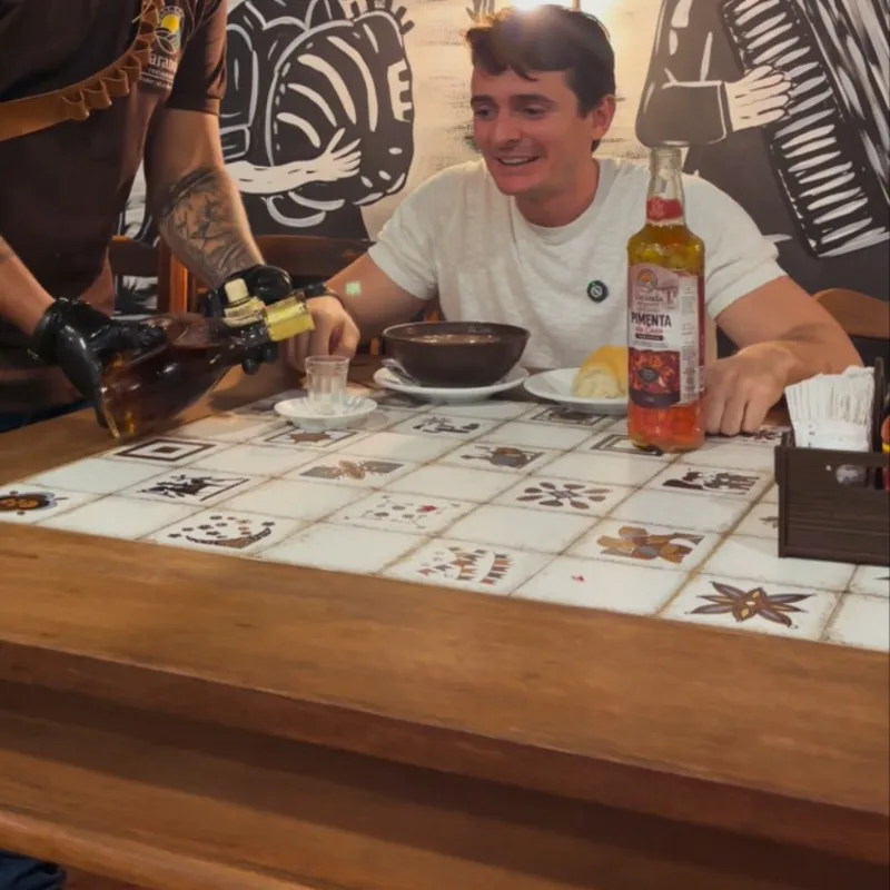 Mesa de madeira com tampo de azulejos e caldinho na cumbuca