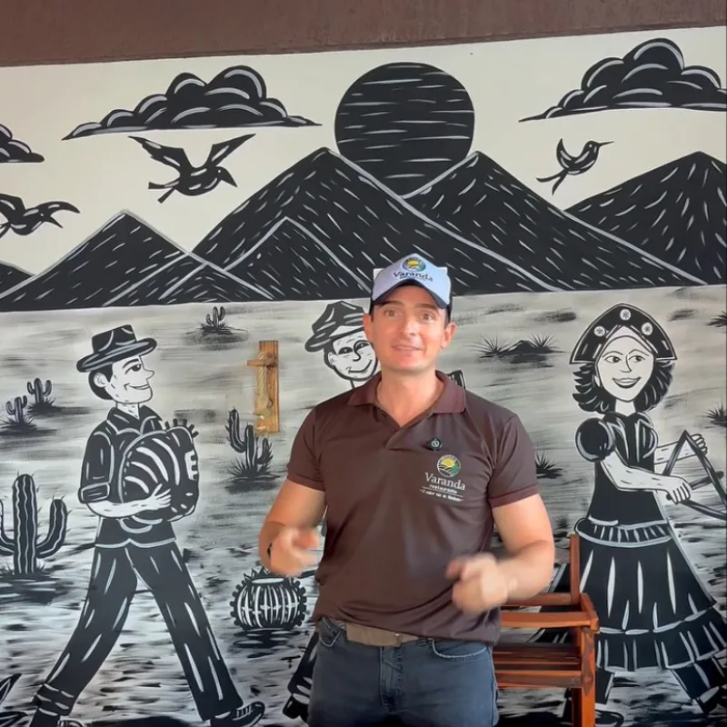 Mural em xilogravura na parede do salão, com sol, serras e forrozeiros