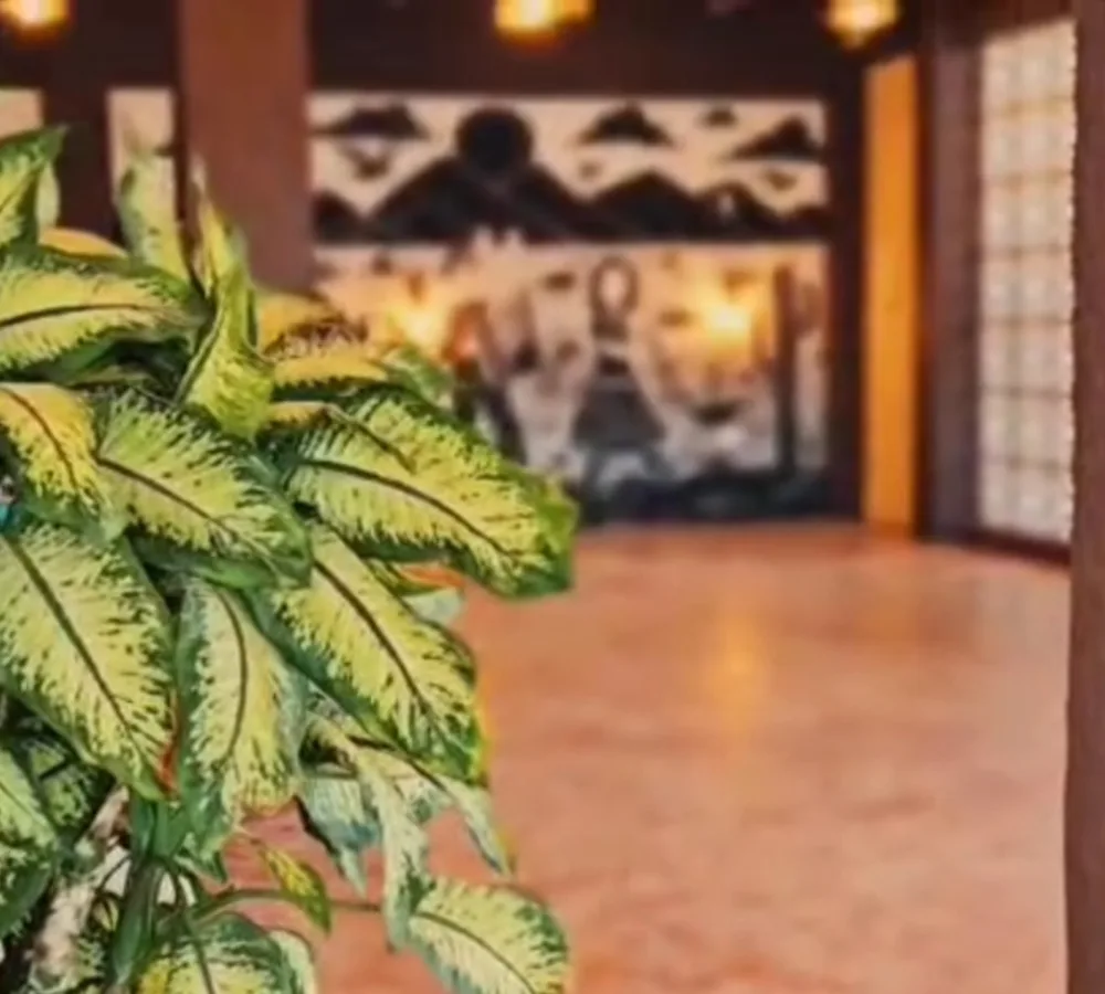 Salão do Varanda à noite, com luzes acesas e o mural ao fundo